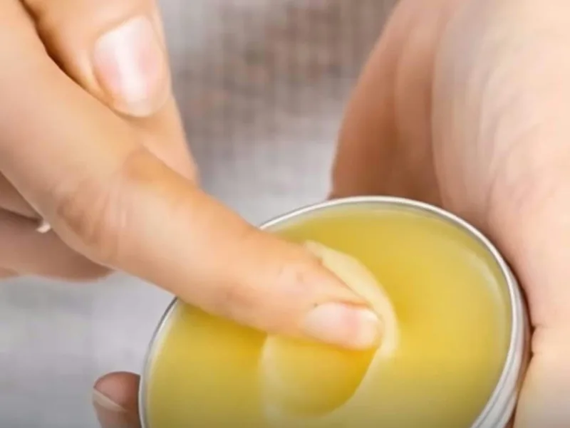 Scooping TheraWolf Relief Balm with a fingertip